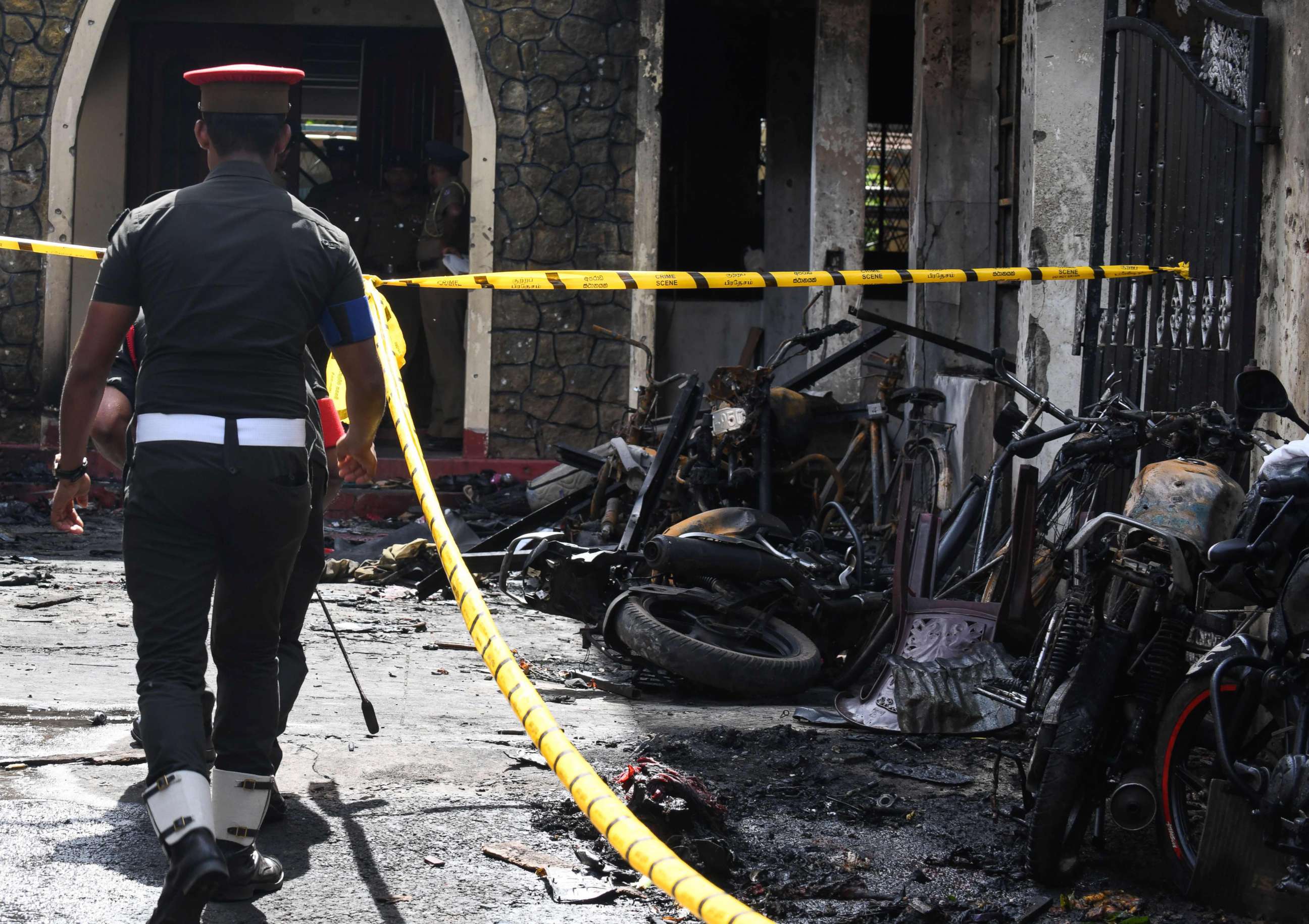 PHOTO: Sri Lankan security personnel walk past debris outside Zion Church following an explosion in Batticaloa, Sri Lanka, April 21, 2019. 