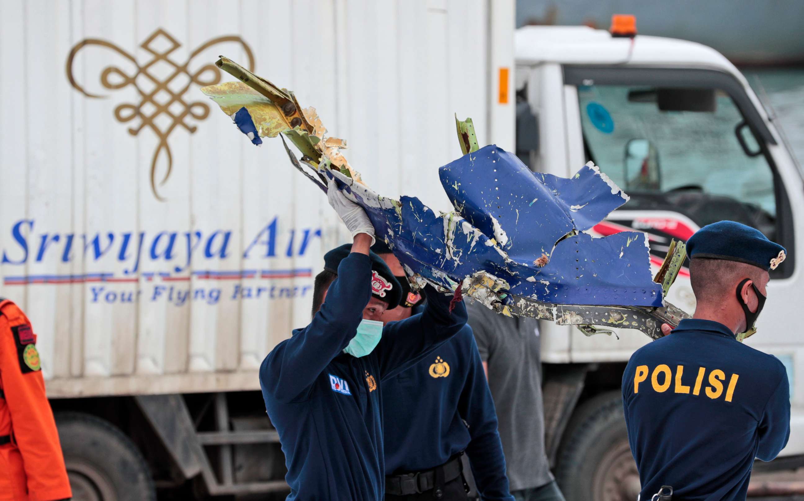 PHOTO: Indonesian police officers carry a part of an aircraft recovered from the Java Sea, where a Sriwijaya Air passenger jet crashed, at the Port of Tanjung Priok in Jakarta, Indonesia, on Jan. 11, 2021.
