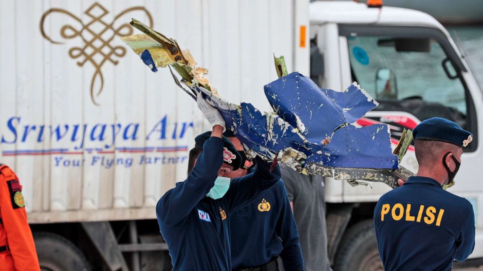 PHOTO: Indonesian police officers carry a part of an aircraft recovered from the Java Sea, where a Sriwijaya Air passenger jet crashed, at the Port of Tanjung Priok in Jakarta, Indonesia, on Jan. 11, 2021.