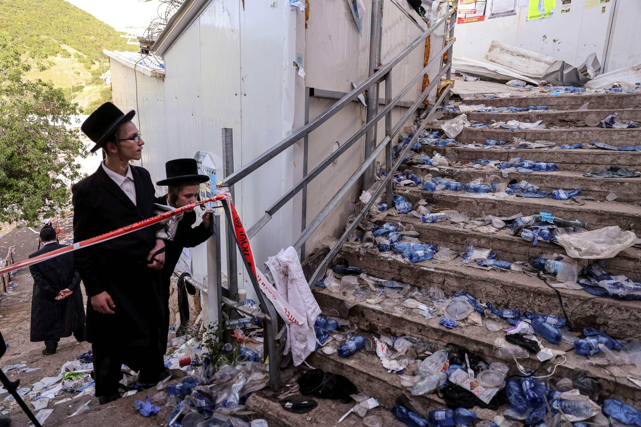 PHOTO: Ultra Orthodox Jews look at stairs littered with refuse in Mount Meron, northern Israel, where a stampede killed scores during an annual religious commemoration that include all-night prayer and dance, April 30, 2021.