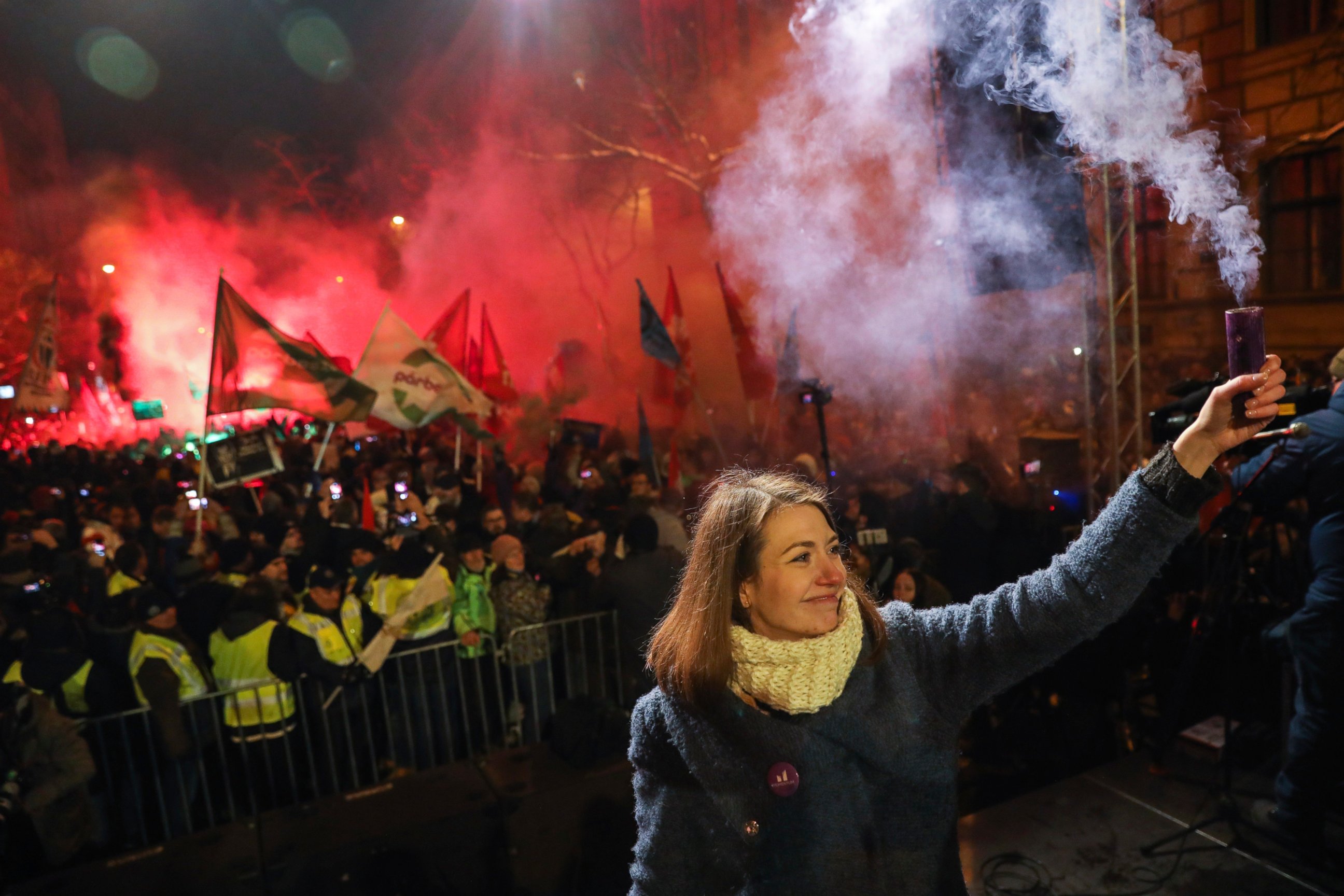 Vice-chairperson of Momentum party Anna Donath holds up a smoke grenade during an anti-government protest in the downtown of Budapest, Hungary, Sunday, Dec. 16, 2018. (Balazs Mohai/MTI via AP)