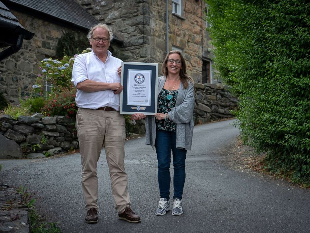 PHOTO: Gwyn Headley and Sarah Badhan, stand on Ffordd Pen Llech with a certificate from Guinness World Records, confirming that the road is the steepest street in the world, in the seaside town of Harlech, North Wales.