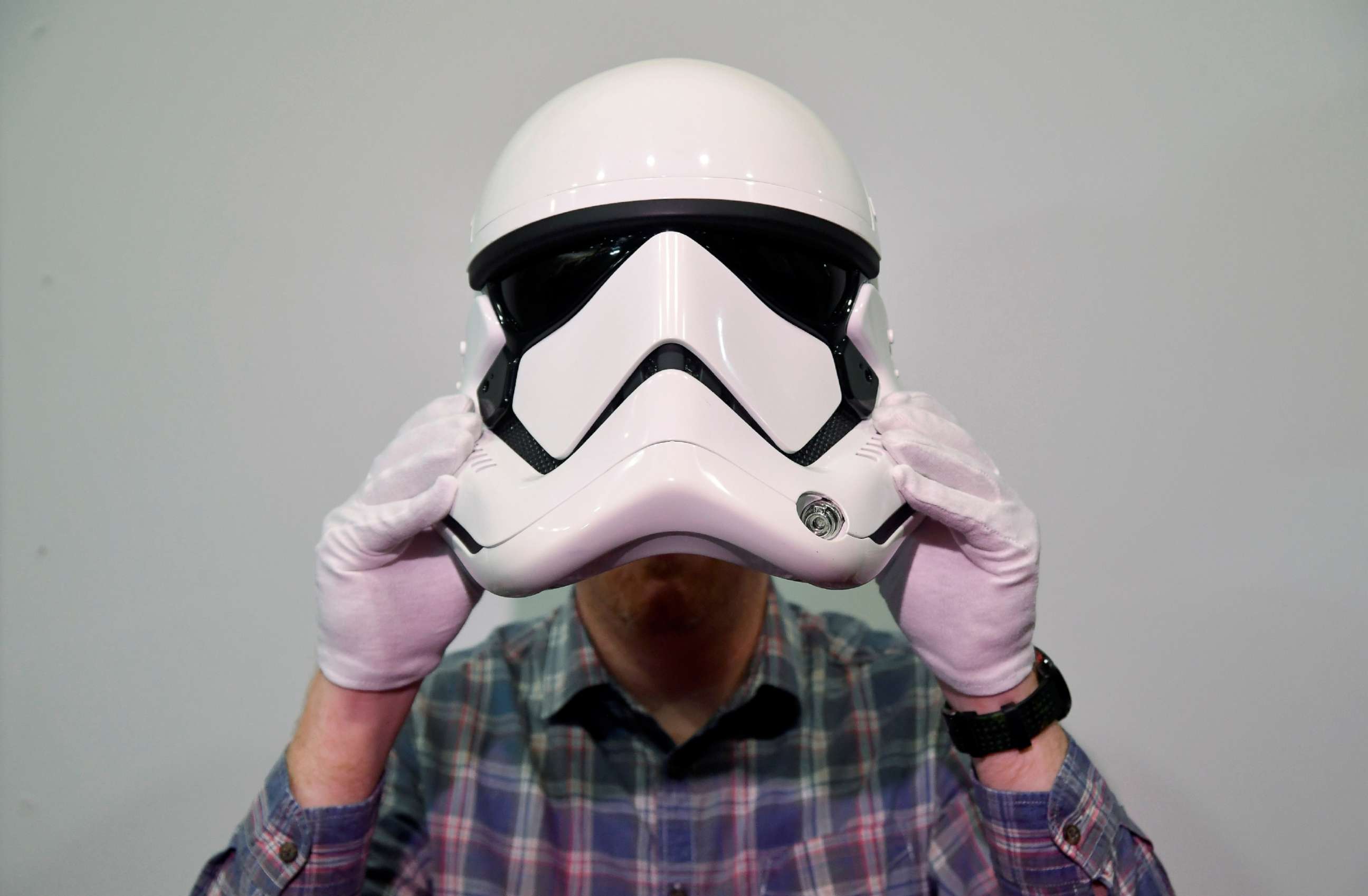 PHOTO: An employee poses with a Stormtrooper helmet from the 2017 film Star Wars: The last Jedi,  on display at the IMAX ahead of being auctioned in London, Sept. 6, 2018.
