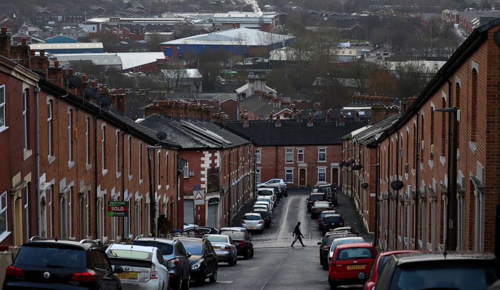 PHOTO: A person walks across a street lined with terraced housing in Blackburn, Lancashire county, northwestern England, on Jan. 17, 2022.