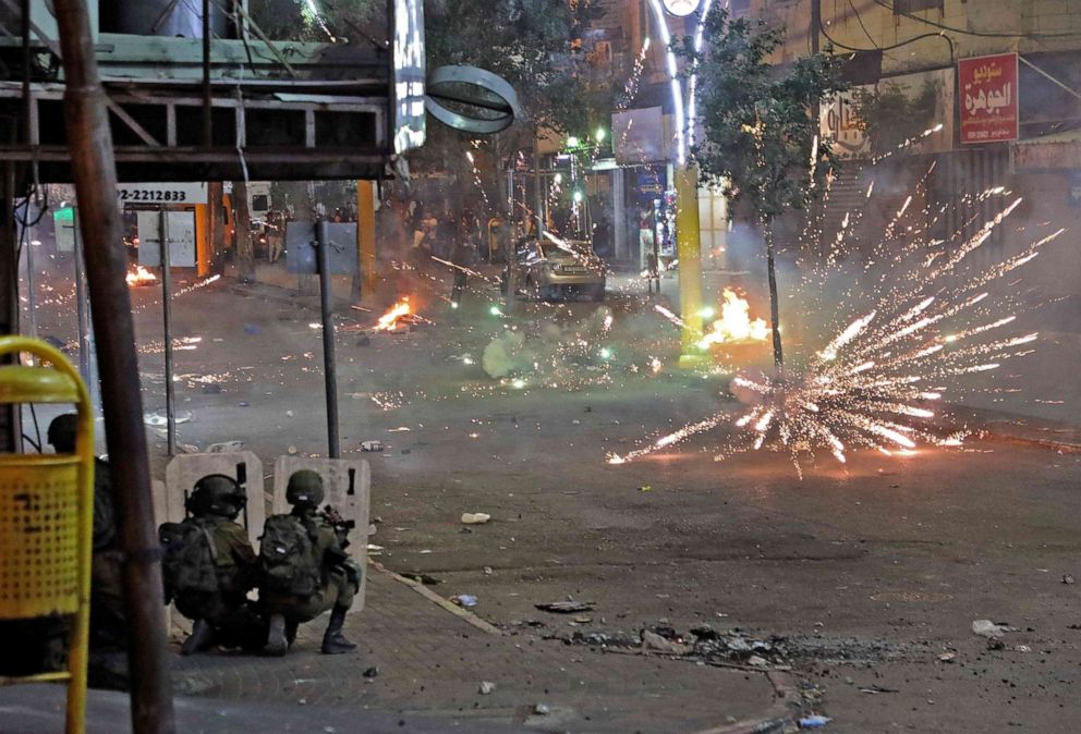 PHOTO: Palestinians clash with Israeli security forces in the city centre of the West Bank town of Hebron, May 12,2021.