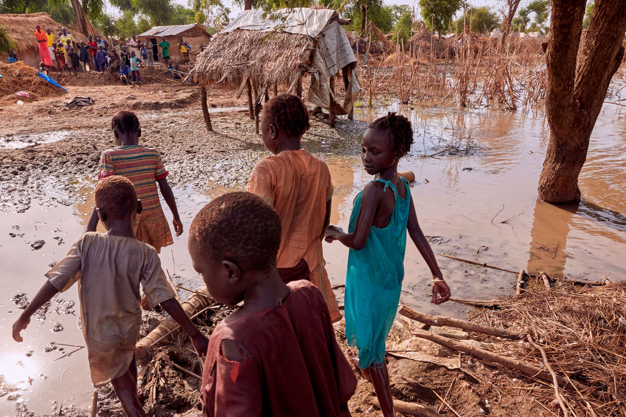 PHOTO: Children walk through the remaining flood waters in Yusuf Batir refugee camp in Maban, South Sudan on Nov. 25, 2019.