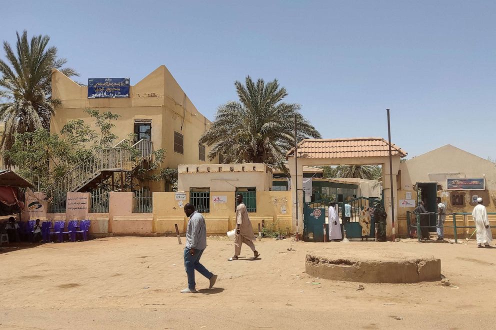 PHOTO: Sudanese walk outside Bashir hospital in southern Khartoum on May 26, 2023, as fighting eased in Sudan following a cease-fire.