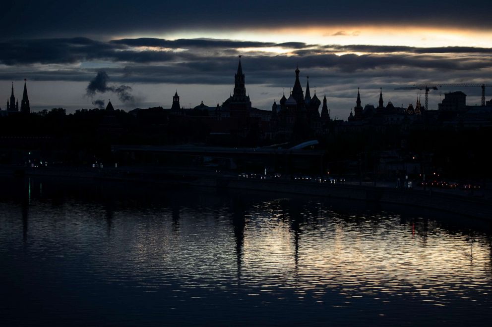 PHOTO: The Kremlin, left, and St. Basil Cathedral, center right, are reflected in the Moskva River during sunset in Moscow, Russia, on May 20, 2020.