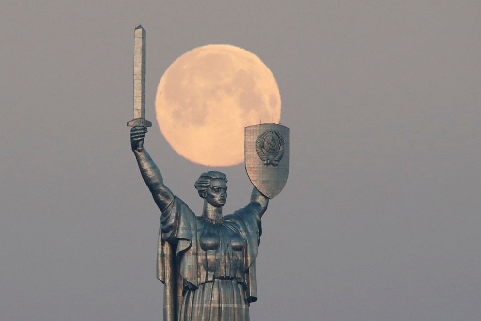 PHOTO: The Pink Supermoon sets behind the giant 'Mother of the Motherland' monument in central Kiev, Ukraine, April 8, 2020.