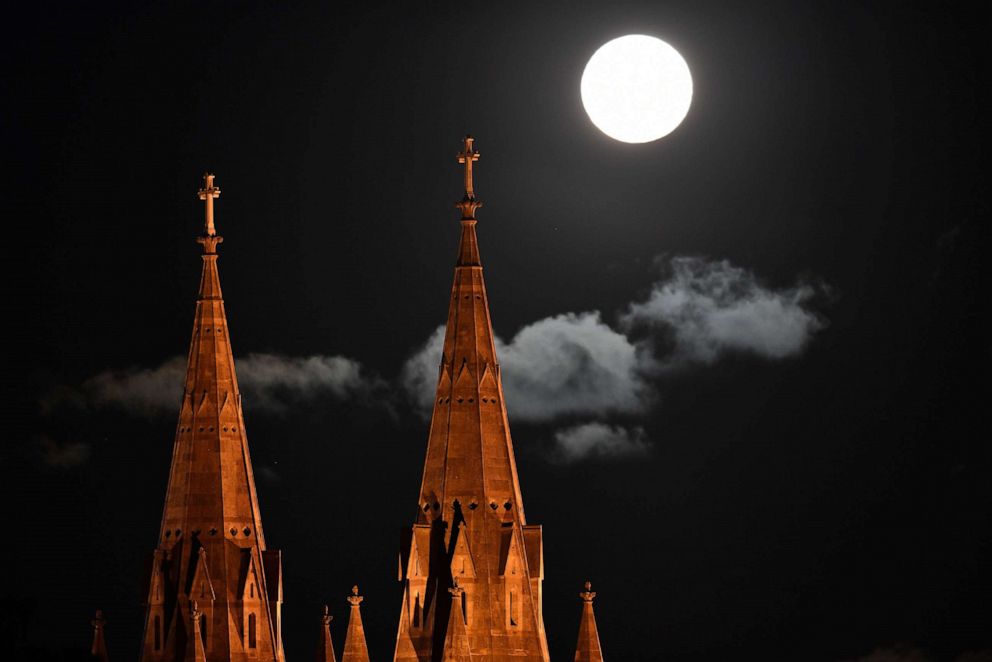 PHOTO: The moon rises over Saint Peters Cathedral in Adelaide, Australia, April 8, 2020.