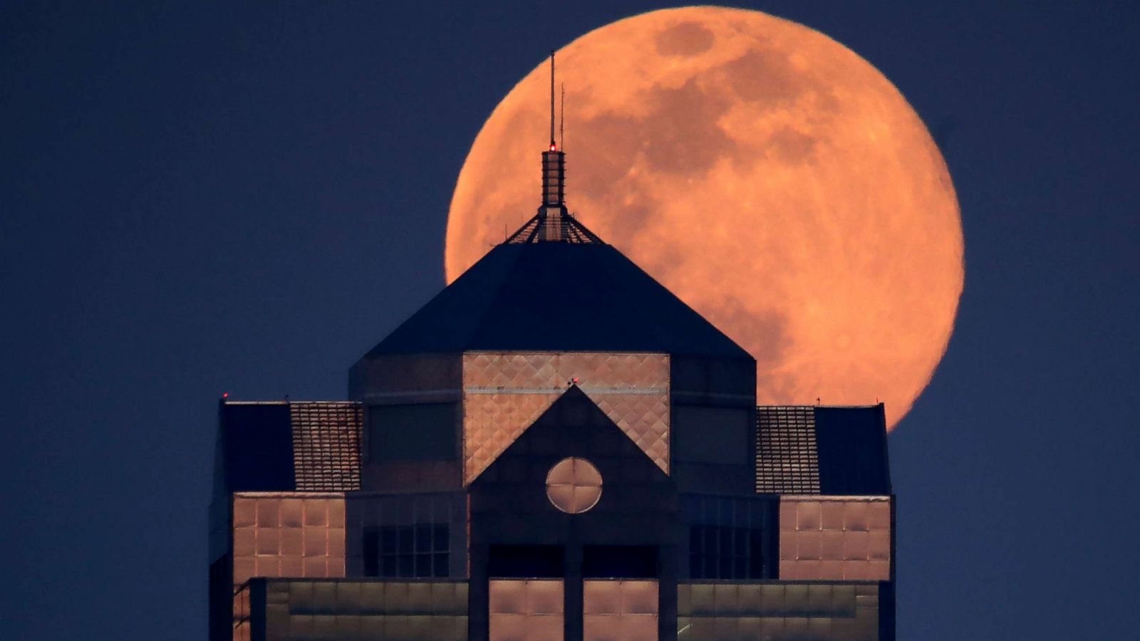 PHOTO: The supermoon rises behind a downtown office building in Kansas City, Mo., April 7, 2020.