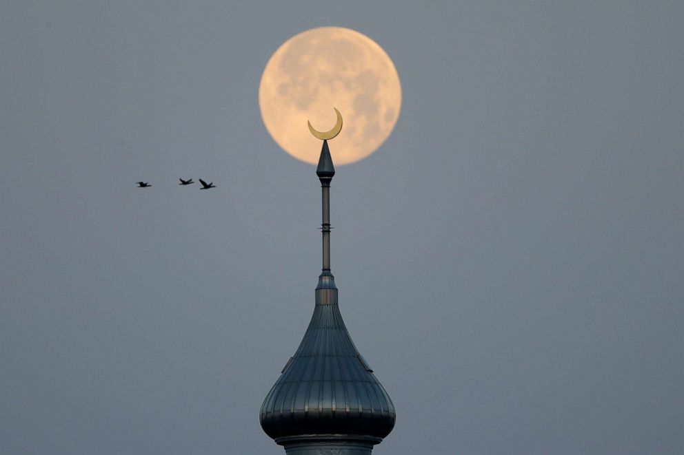PHOTO:The full pink supermoon sets behind the minarets on the University of Tampa campus, April 8, 2020, in Tampa, Fla.