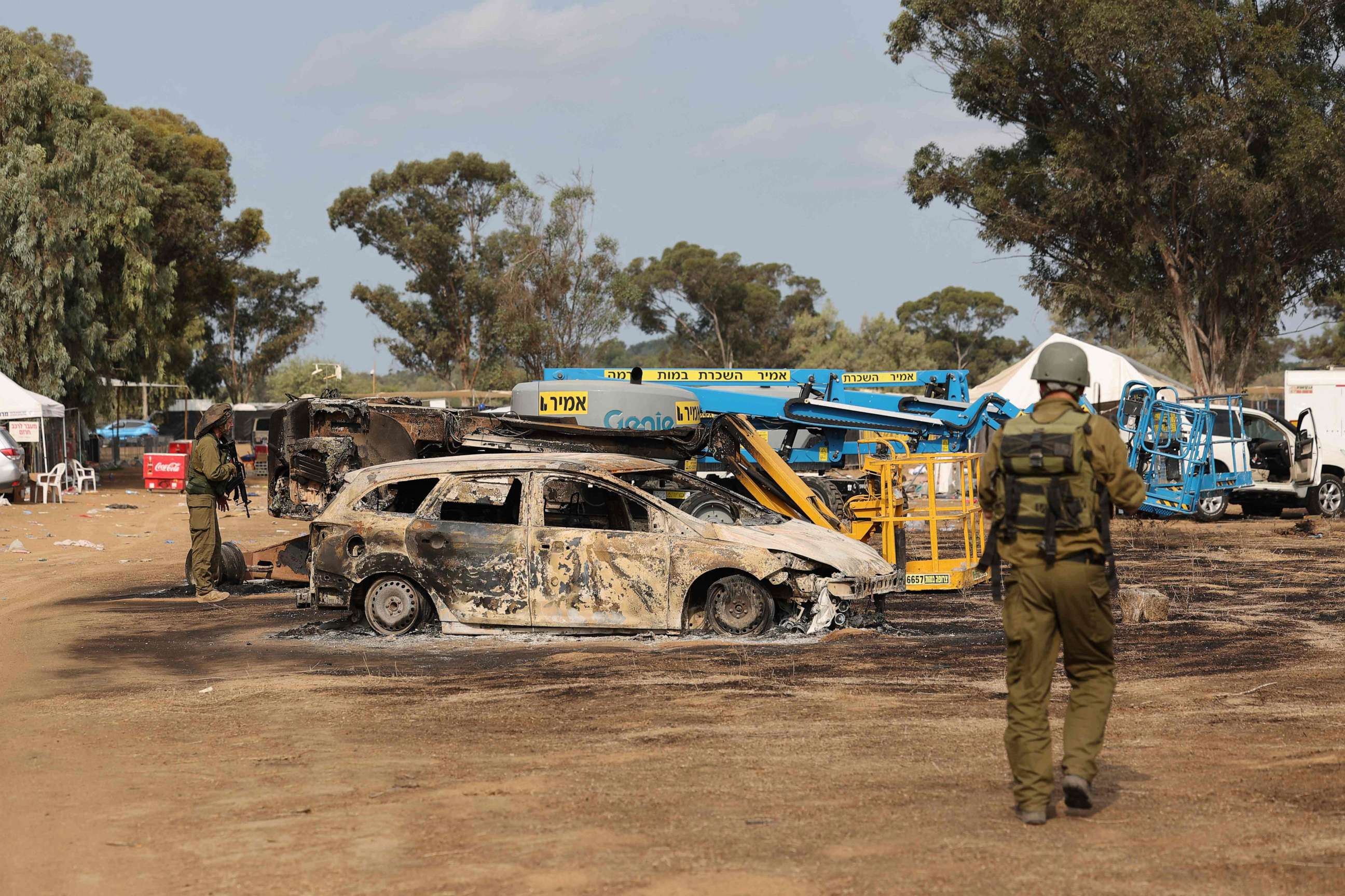 PHOTO: TOPSHOT - Israeli troops inspect the ravaged site of the weekend attack on the Supernova desert music Festival by Palestinian militants near Kibbutz Reim in the Negev desert in southern Israel on October 10, 2023.