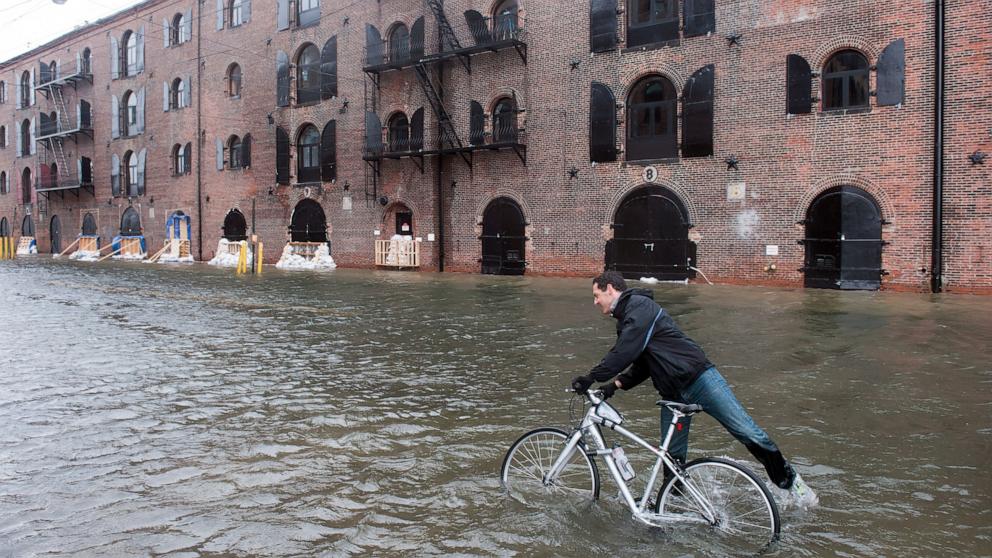 PHOTO: A man tries to ride his bike through floodwaters on Van Brunt Street in Red Hook, Brooklyn, New York, as Hurricane Sandy slowly makes its way through New York City on Oct. 29, 2012.