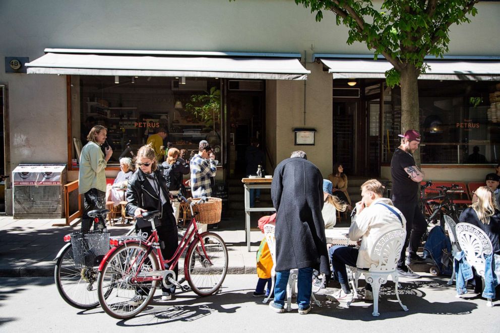 PHOTO: Customers gather at terraced tables outside a cafe in Stockholm, Sweden, May 22, 2020.