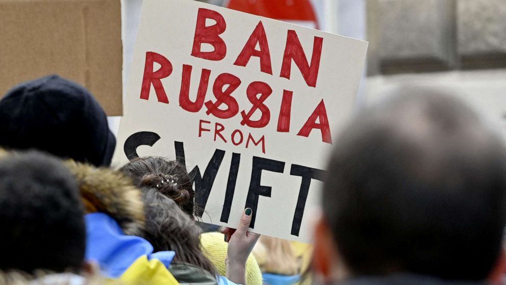 PHOTO: A demonstrator holds a poster reading "Ban Russia from SWIFT" during a protest against Russia's invasion of Ukraine, Feb. 26, 2022, in front of the Russian embassy in Vienna, Austria.