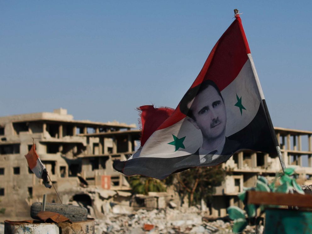 PHOTO: A Syrian national flag with the picture of the Syrian President Bashar Assad hangs at an Army check point, in the town of Douma in the eastern Ghouta region, Syria, July 15, 2018.