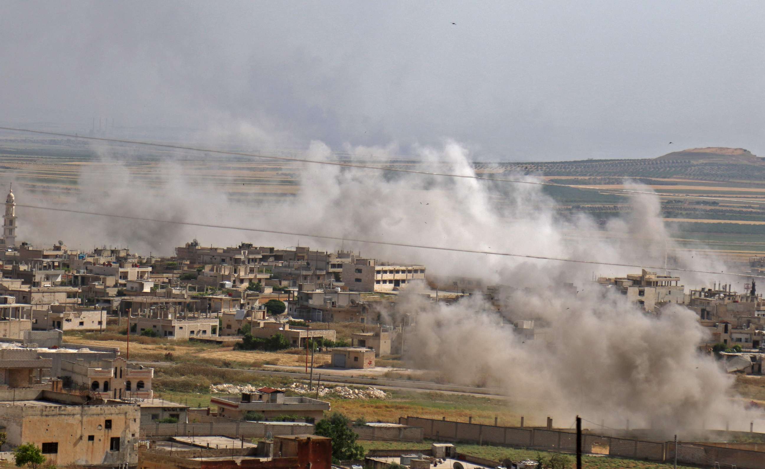 PHOTO: Smoke plumes are seen following a reported Syrian government forces' bombardment on the town of Khan Sheikhun in the southern countryside of the rebel-held Idlib province, May 22, 2019. 