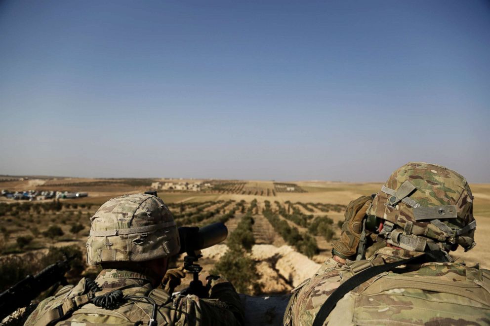 PHOTO: American troops look out toward the border with Turkey from a small outpost near the town of Manbij,  northern Syria Feb. 7, 2018. 