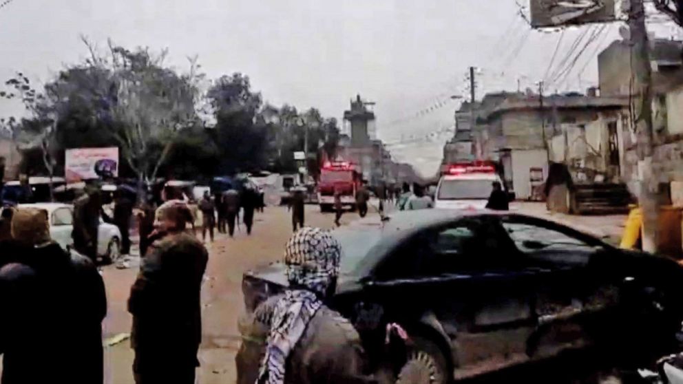 PHOTO: An image grab taken from a video published by Hawar News Agency (ANHA) on January 16, 2019, shows people gathered at the scene of a suicide attack in the northern Syrian town of Manbij.