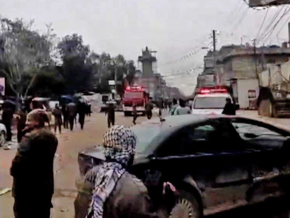 PHOTO: An image grab taken from a video published by Hawar News Agency (ANHA) on January 16, 2019, shows people gathered at the scene of a suicide attack in the northern Syrian town of Manbij.