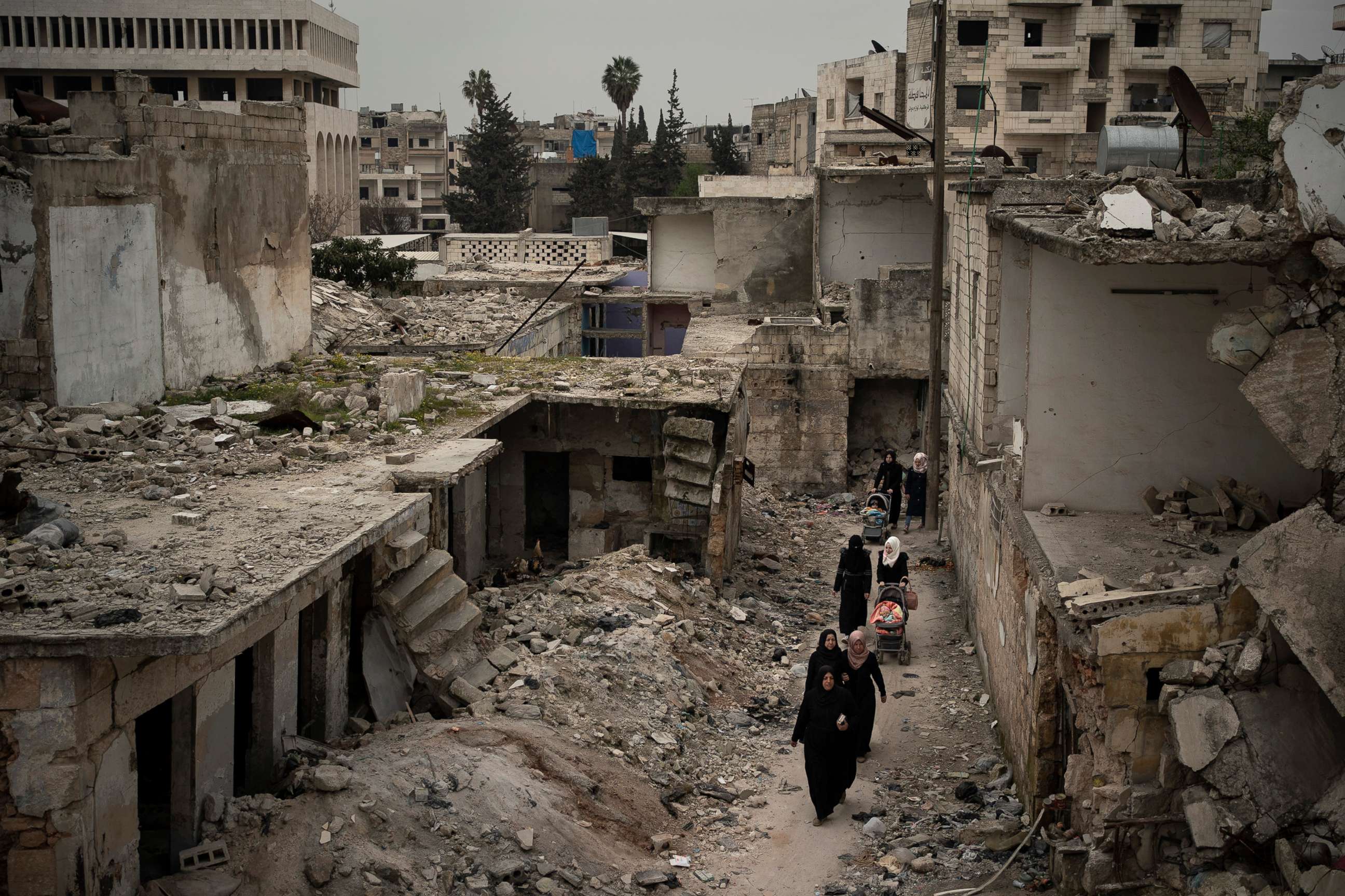 PHOTO: Women walk in a neighborhood heavily damaged by airstrikes in Idlib, Syria, March 12, 2020.