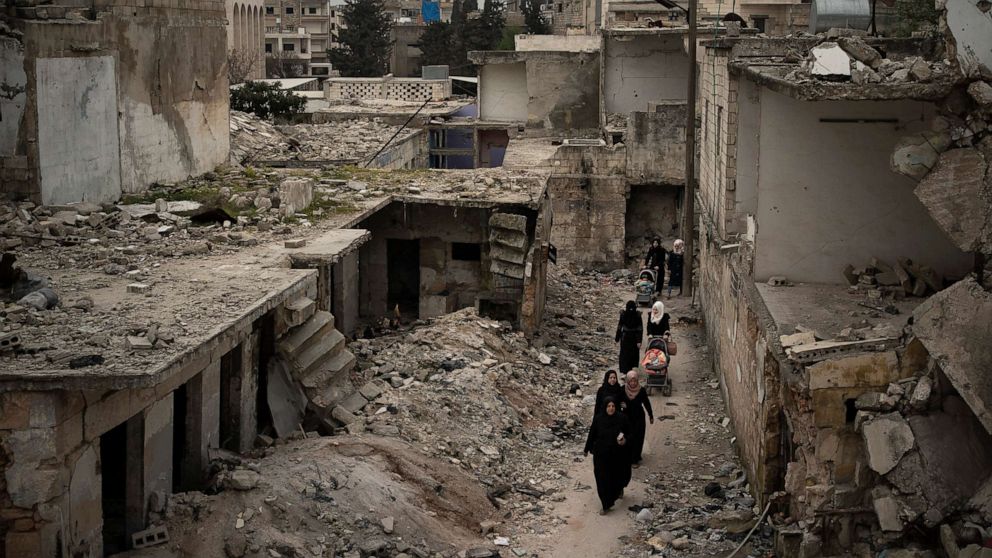 PHOTO: Women walk in a neighborhood heavily damaged by airstrikes in Idlib, Syria, March 12, 2020.