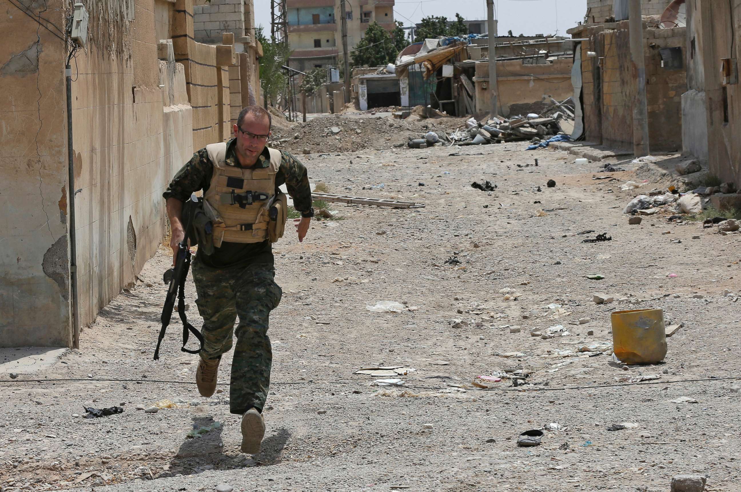PHOTO: Macer Gifford, a 30-year former City broker in London, who fights with an Assyrian militia, runs to take cover from IS sniper fire, on the western side of Raqqa, northeast Syria, July 17, 2017.