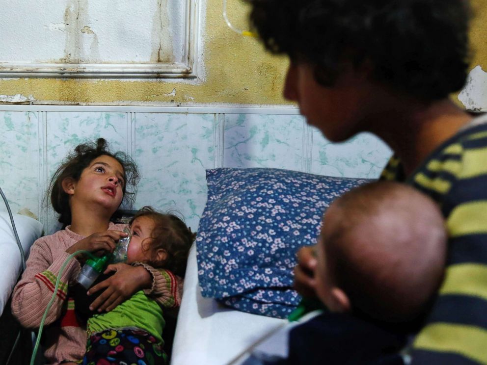 PHOTO: A Syrian girl holds an oxygen mask over the face of an infant at a makeshift hospital following a reported gas attack on the rebel-held besieged town of Douma, in the eastern Ghouta region, on the outskirts of Damascus, Syria, Jan. 22, 2018.