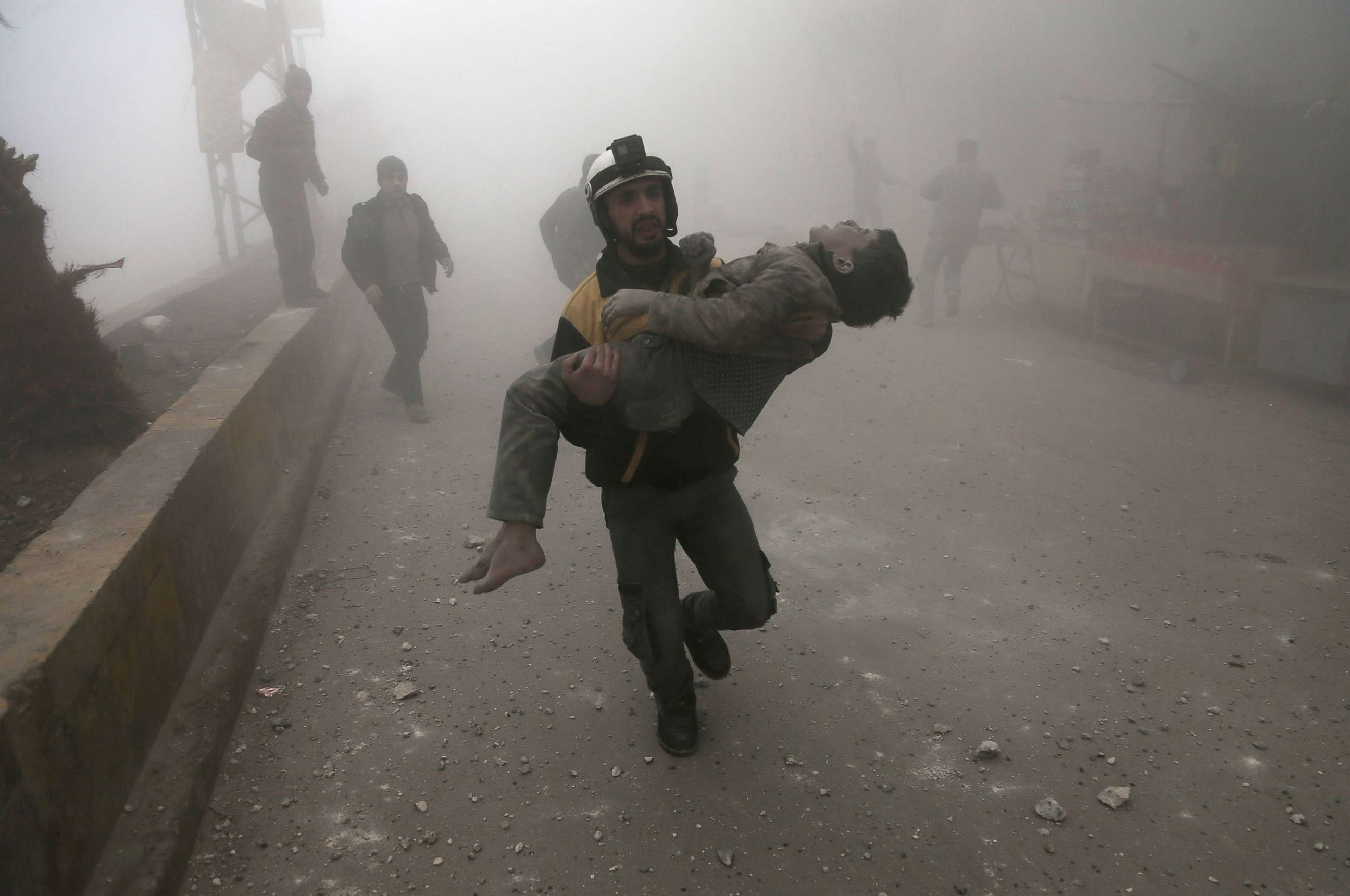 PHOTO: A volunteer from the Syrian Civil Defence, known as the White Helmets, carries a wounded boy after digging him out of the rubble following an air strike in the besieged rebel-held Eastern Ghouta area near Damascus, Syria, Jan. 9, 2018.
