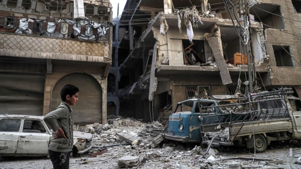 A boy surveys a street covered in rubble after air strikes in Douma, Syria, Nov. 17. 2017, that killed at least thirteen civilians, including three white helmets volunteers, according to local sources.