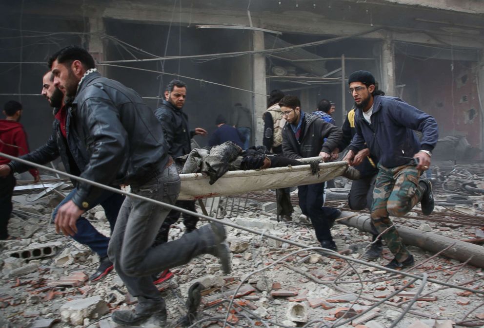 PHOTO: Syrians evacuate badly injured people following regime strikes on the besieged rebel-held enclave of Kafr Batna near Damascus, Feb. 6, 2018 where some 35 civilians were killed.