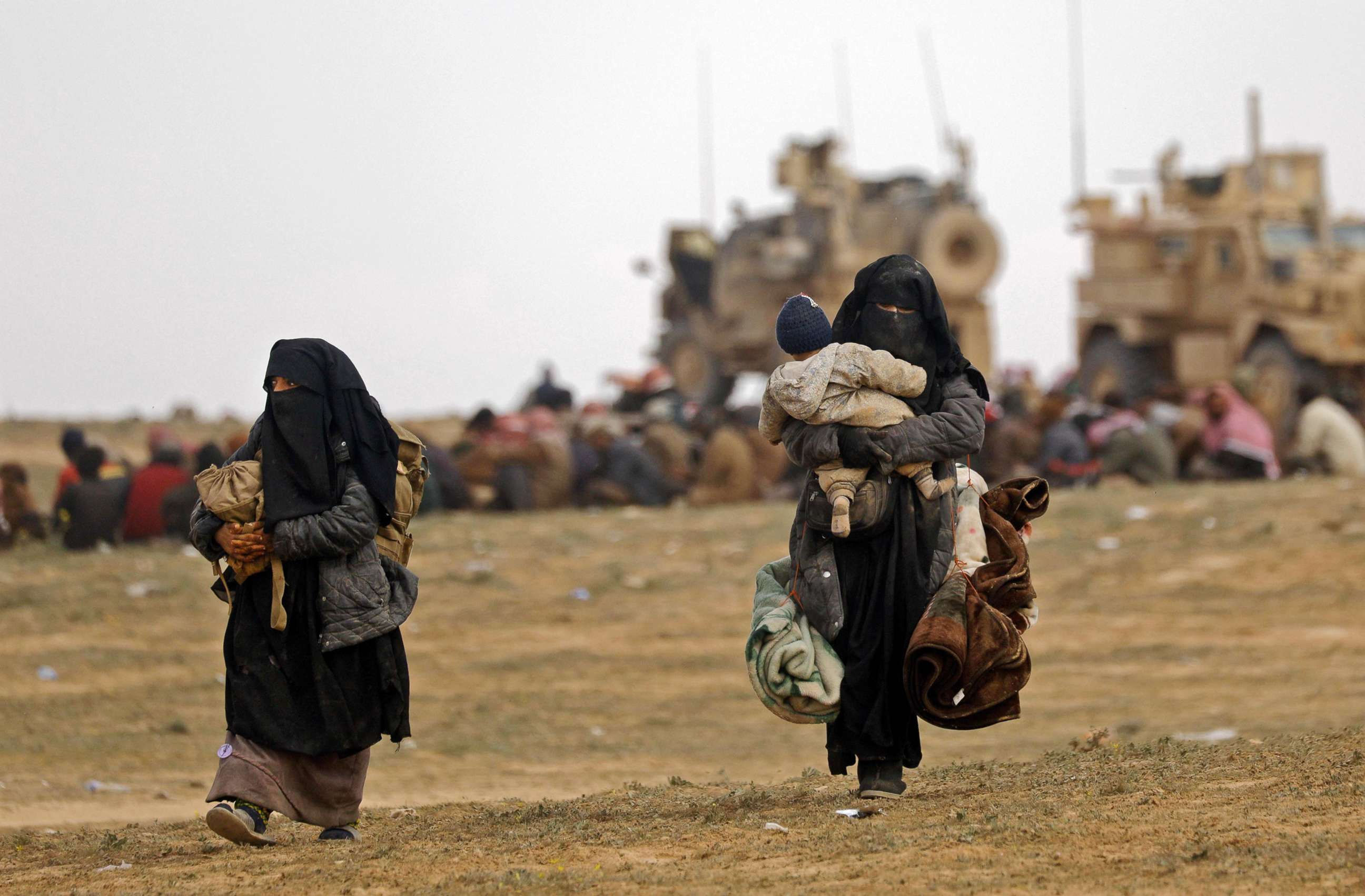 PHOTO: Civilians fleeing the ISIS embattled holdout of Baghouz walk in a field on Feb. 13, 2019, during an operation by the U.S.-backed Syrian Democratic Forces (SDF) to expel the group from the area, in the eastern Syrian province of Deir Ezzor.