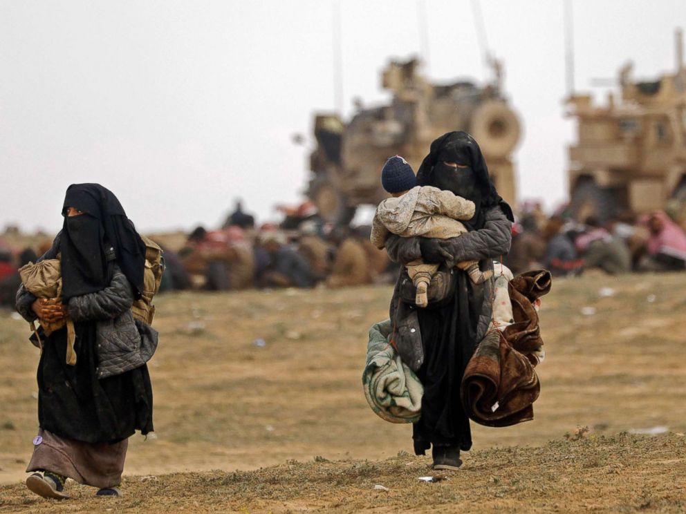 PHOTO: Civilians fleeing the ISIS embattled holdout of Baghouz walk in a field on Feb. 13, 2019, during an operation by the U.S.-backed Syrian Democratic Forces (SDF) to expel the group from the area, in the eastern Syrian province of Deir Ezzor.