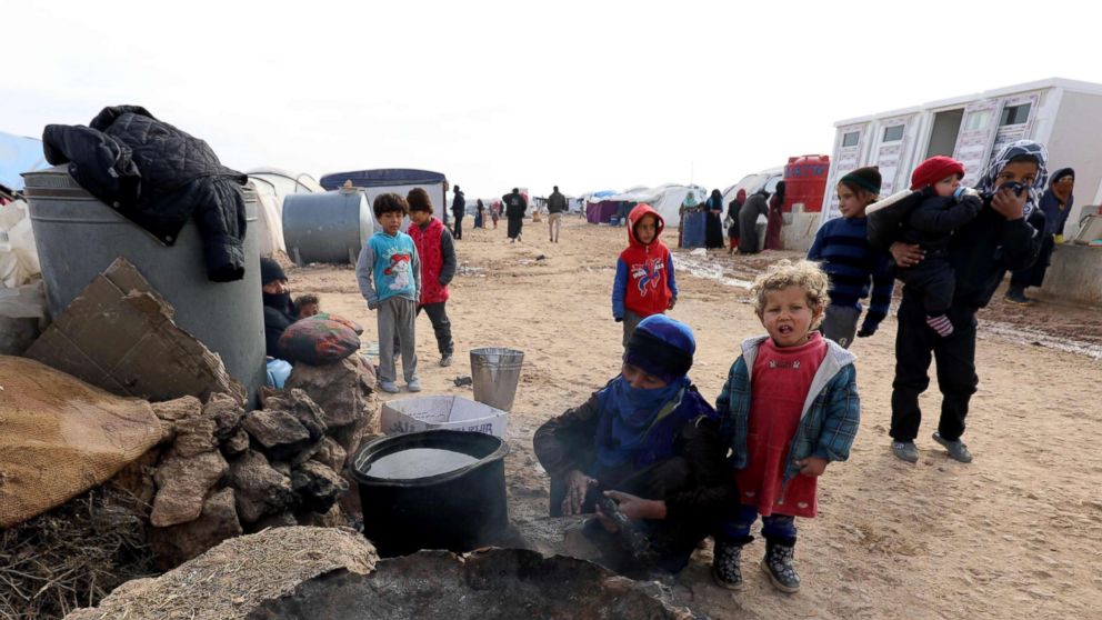 Displaced Syrians, from the eastern city of Deir Ezzor and Raqqa who were forced to leave by the war against the Islamic State group, prepare food at the Ain Issa camp, Dec. 18, 2017.