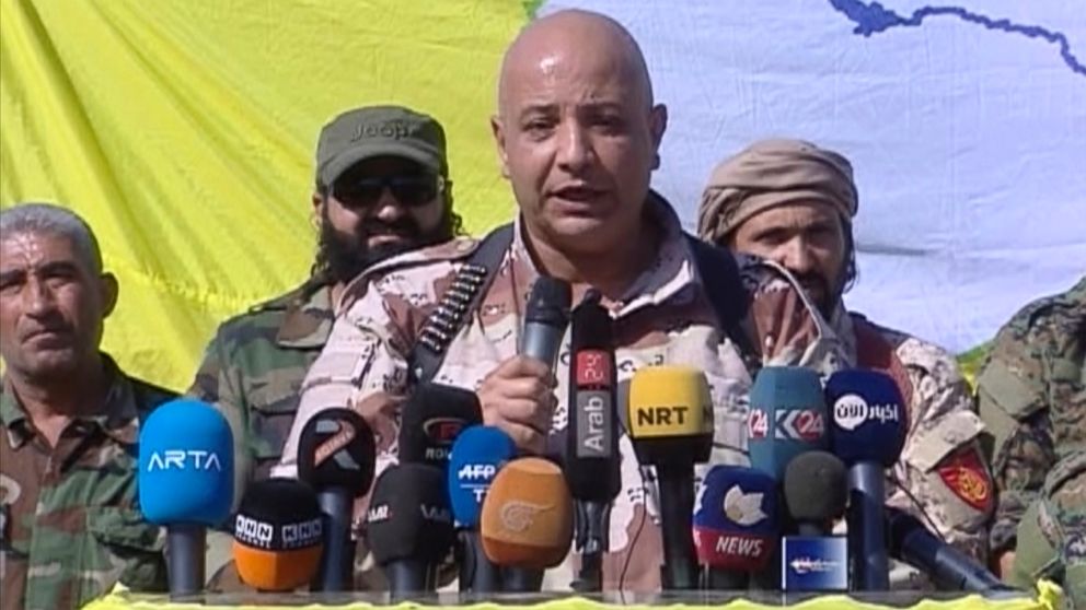 A Kurdish TV channel media outlet, that is consistent with independent AP reporting, shows Talal Sillo, a spokesman and senior SDF commander speaks during a press conference held inside Raqqa city, Syria, Oct. 20, 2017. 