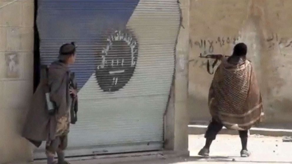 PHOTO: A still image taken from a video posted to a social media website by the Islamic State-affiliated Amaq News Agency, on July 15, 2017, shows a man appearing to be an Islamic State militant firing a weapon, said to be in Raqqa, Syria. 