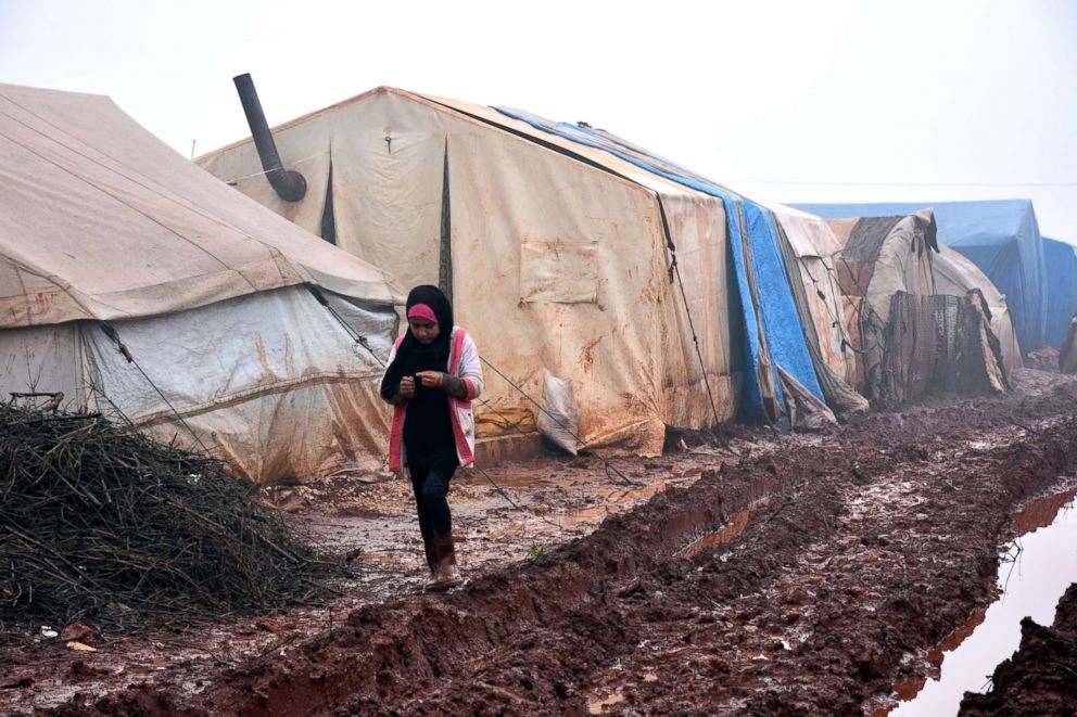 PHOTO: A child walks in the mud outside her shelter at Al-Ihsan refugee camp in Idlib, Syria, Jan. 15, 2019.