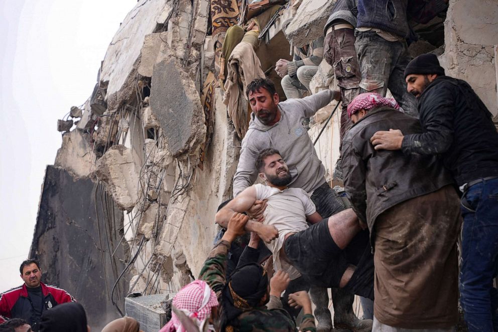 PHOTO: Residents rescue an injured man from the rubble of a collapsed building following an earthquake in the town of Jandaris, in the rebel-held part of Aleppo province, on Feb. 6, 2023.