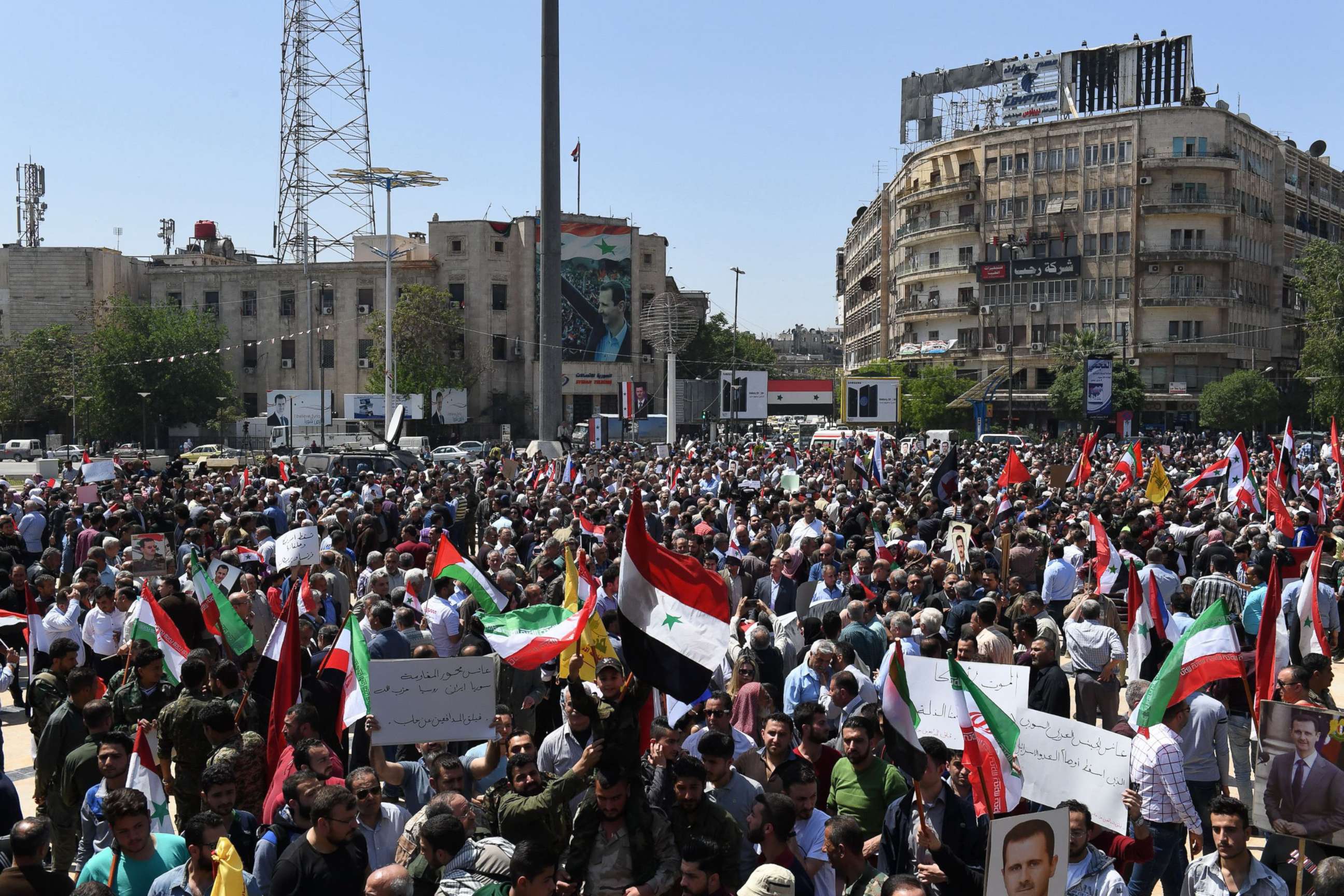 PHOTO: Syrians wave the national flag and portraits of President Bashar al-Assad as they gather in Aleppo's Saadallah al-Jabiri square, April 14, 2018, to condemn the strikes carried out by the United States, Britain and France against the Syrian regime.
