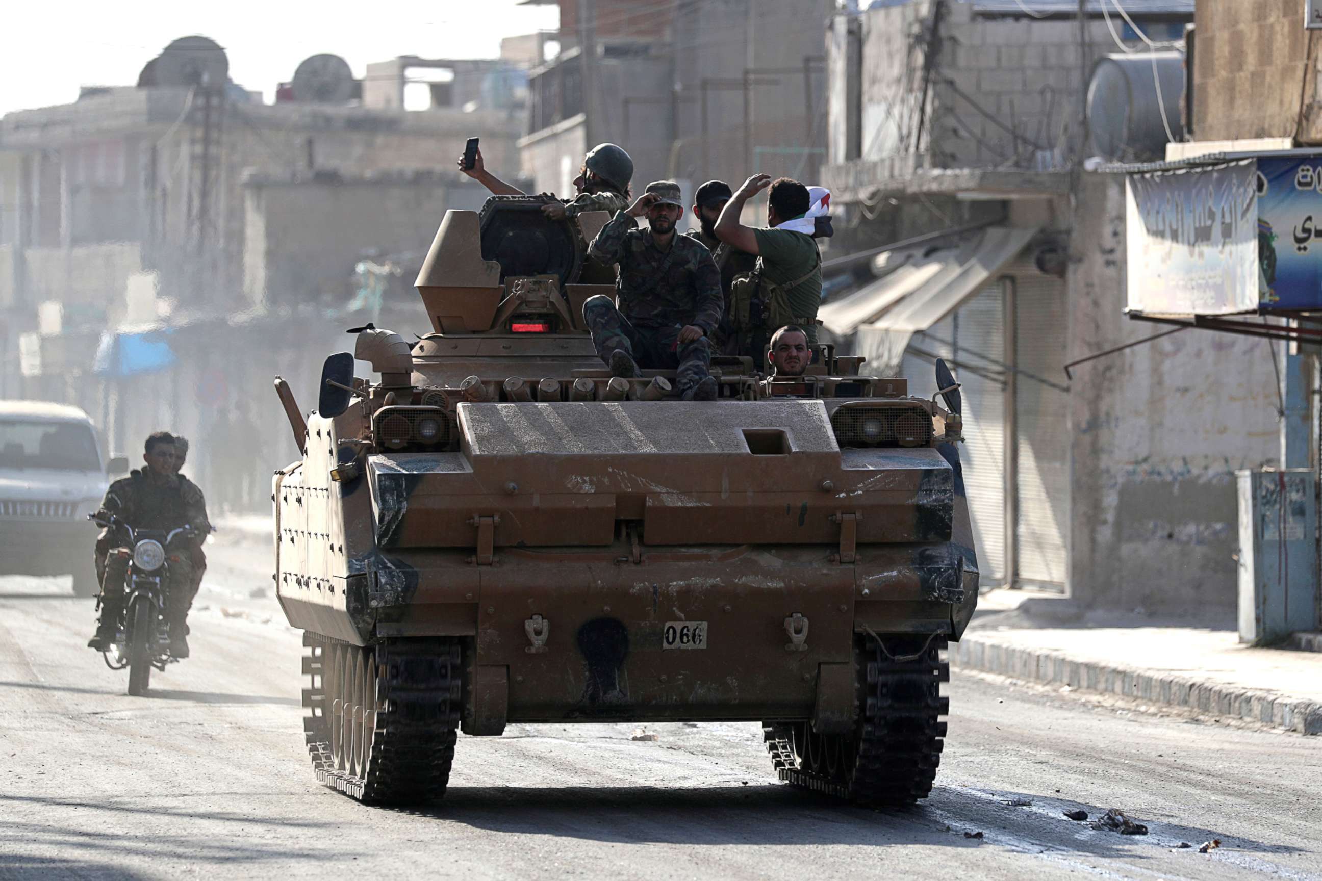 PHOTO: Turkey-backed Syrian rebel fighters are seen on a military vehicle in the town of Tal Abyad, Syria, Oct. 13, 2019.