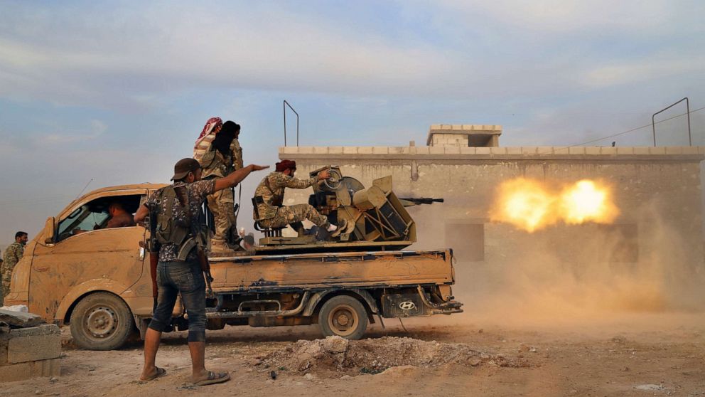 PHOTO: Turkey-backed Syrian opposition fighters fire a heavy machine-gun towards Kurdish fighters, in Syria's northern region of Manbij on Oct. 14, 2019.