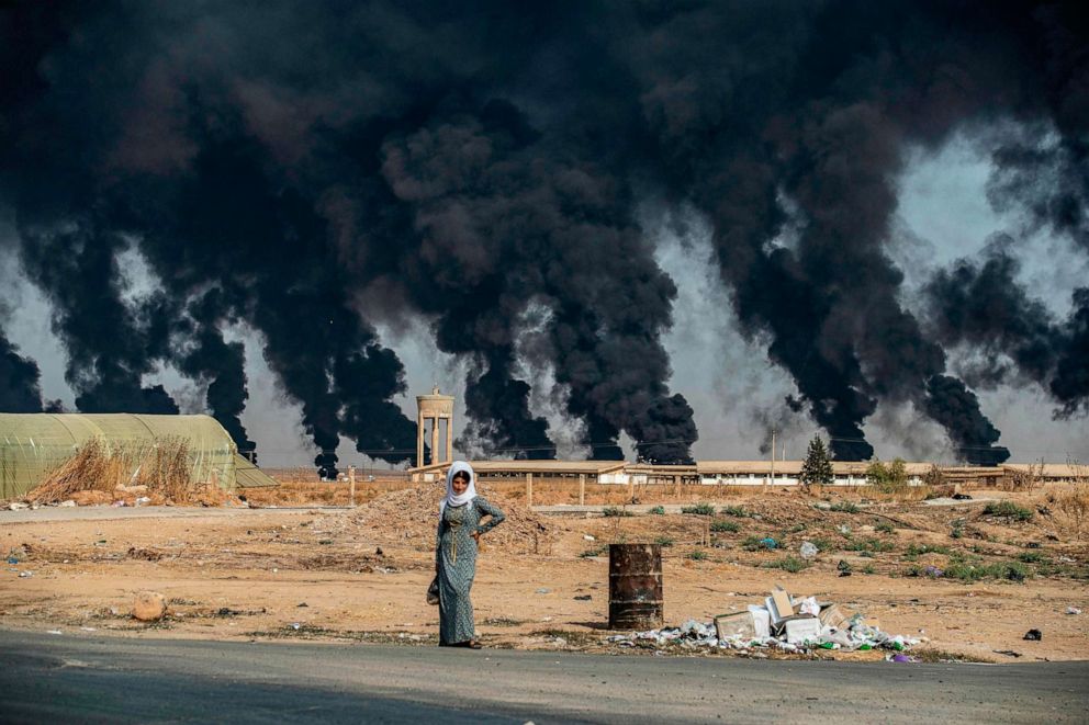 PHOTO: A woman stands along the side of a road on the outskirts of the town of Tal Tamr near the Syrian Kurdish town of Ras al-Ain along the border with Turkey in the northeastern Hassakeh province on Oct. 16, 2019.