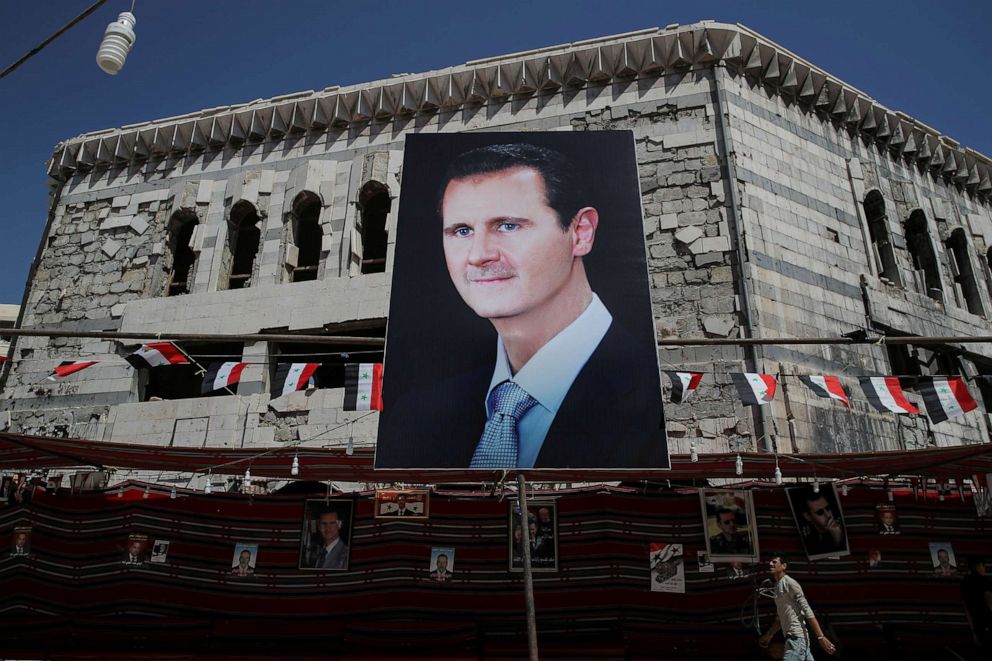 PHOTO: A man walks past a banner depicting Syrian president Bashar al-Assad in Douma, outside Damascus, Syria, Sept. 17, 2018.