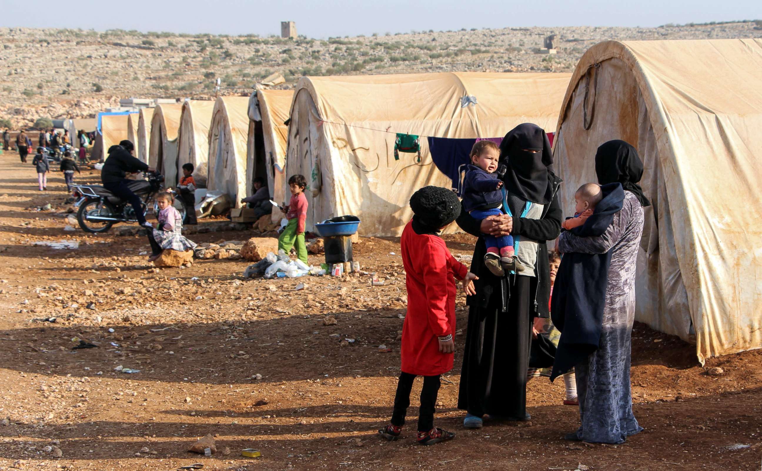 PHOTO: Women and children converse as they stand outside tents at the Furat (Euphrates) camp for the displaced from Deir Ezzor, north of the town of Kafr Dariyan, Syria Nov. 27, 2017. 