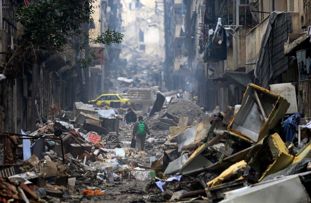 PHOTO: Residents walk through the destruction of the once rebel-held Salaheddine neighborhood in the eastern Aleppo, Syria, Jan. 20, 2017.