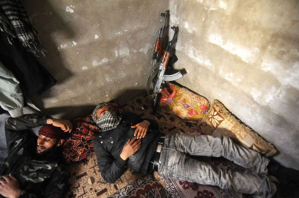 PHOTO: Three Syrian rebels are resting inside bunkers during a lull in the fighting.