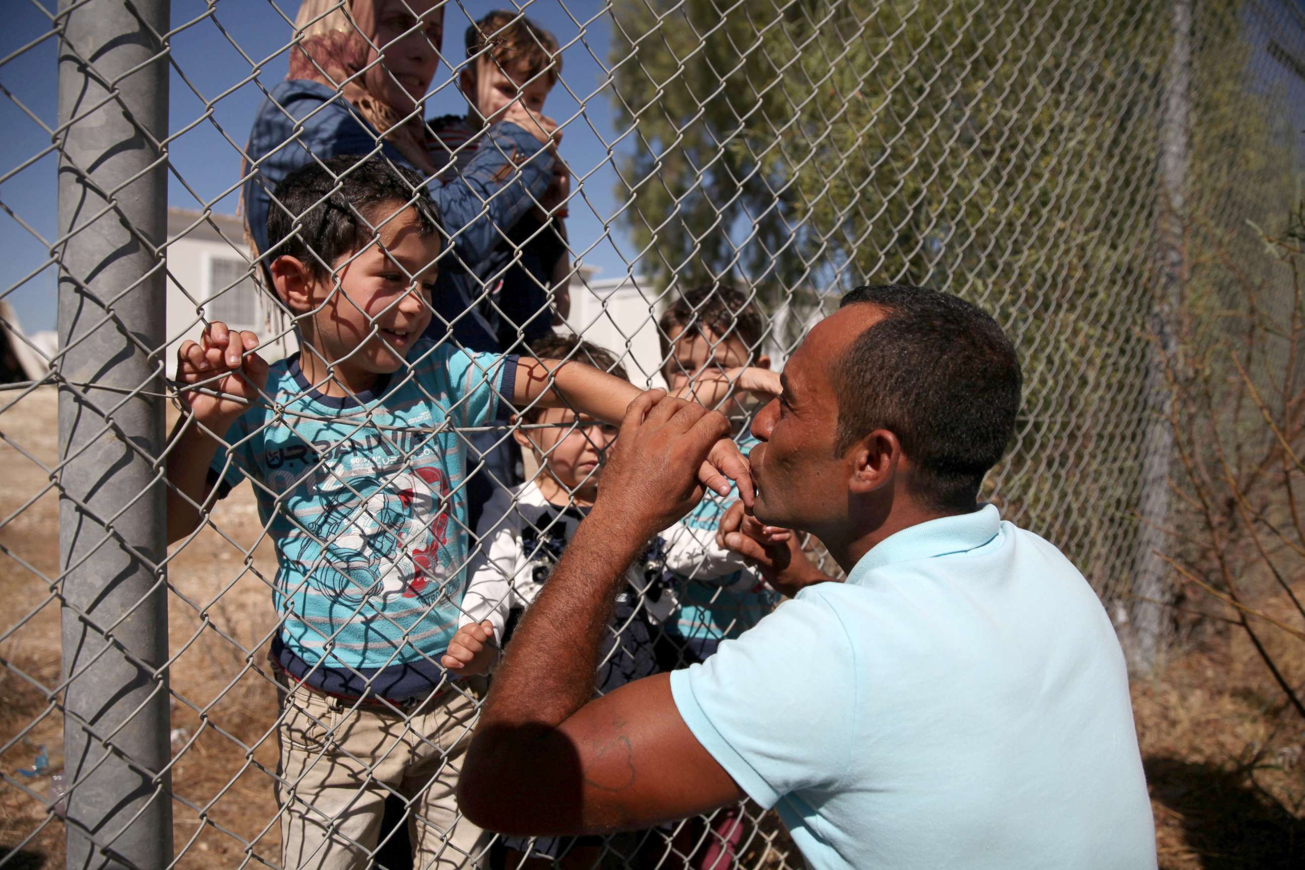 PHOTO: Ammar Hammasho from Syria, who lives in Cyprus, kisses his children who arrived at the refugee camp in Kokkinotrimithia, outside Nicosia, Cyprus, Sept. 10, 2017.