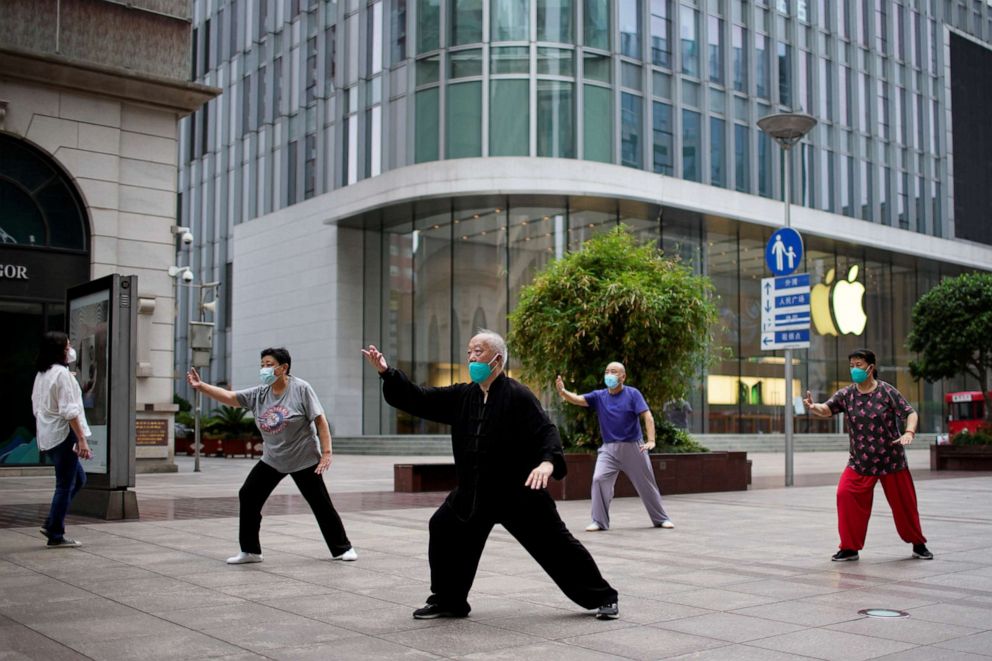 PHOTO: People wearing face masks practise Tai Chi on a shopping street, after the COVDI-19 lockdown was lifted in Shanghai, China, June 1, 2022.