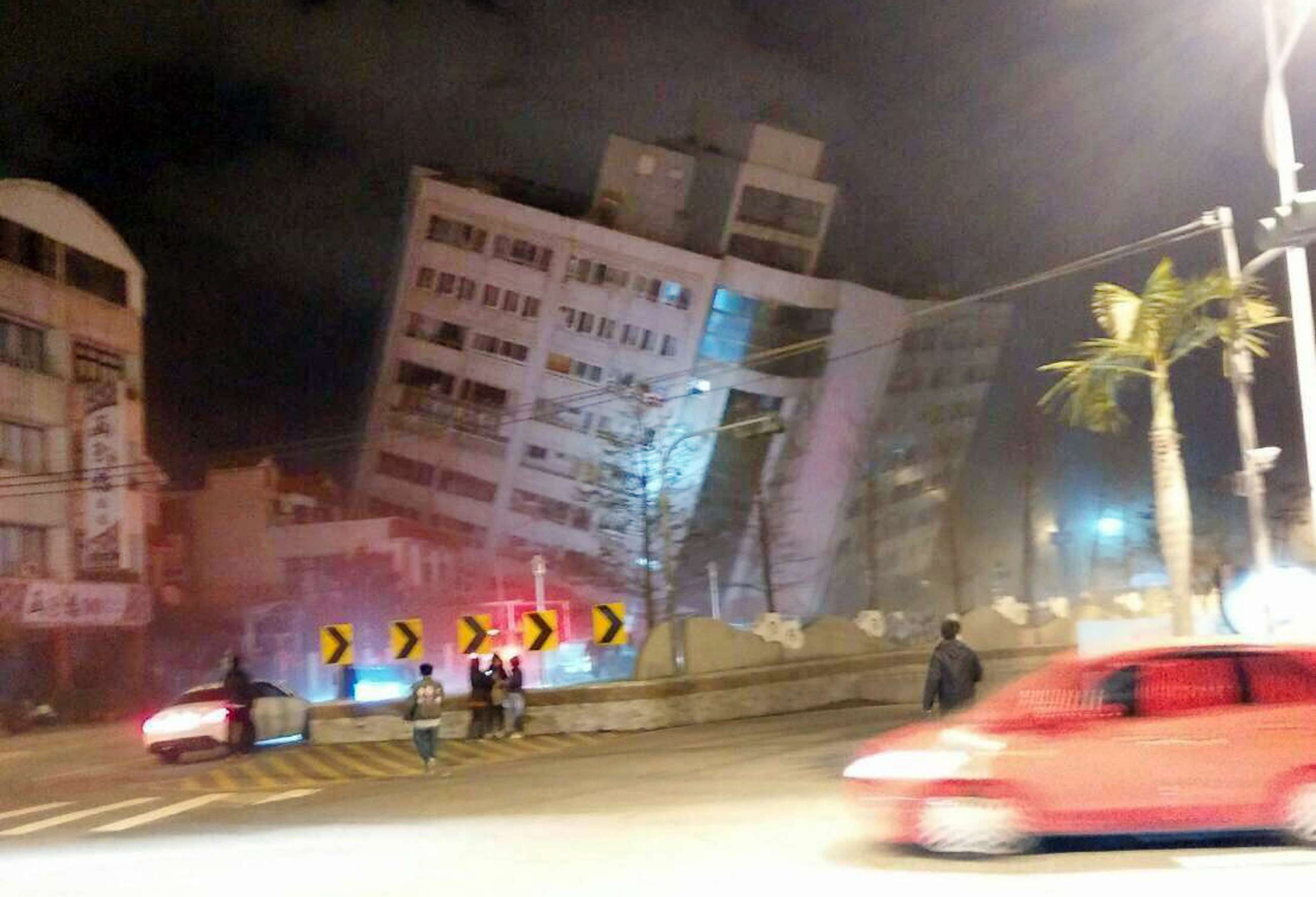 PHOTO: In this photo released by Hualien County Fire Bureau, rescuers are seen entering an building that collapsed onto its side from an early morning earthquake in Hualien County, eastern Taiwan, Feb. 7 2018.